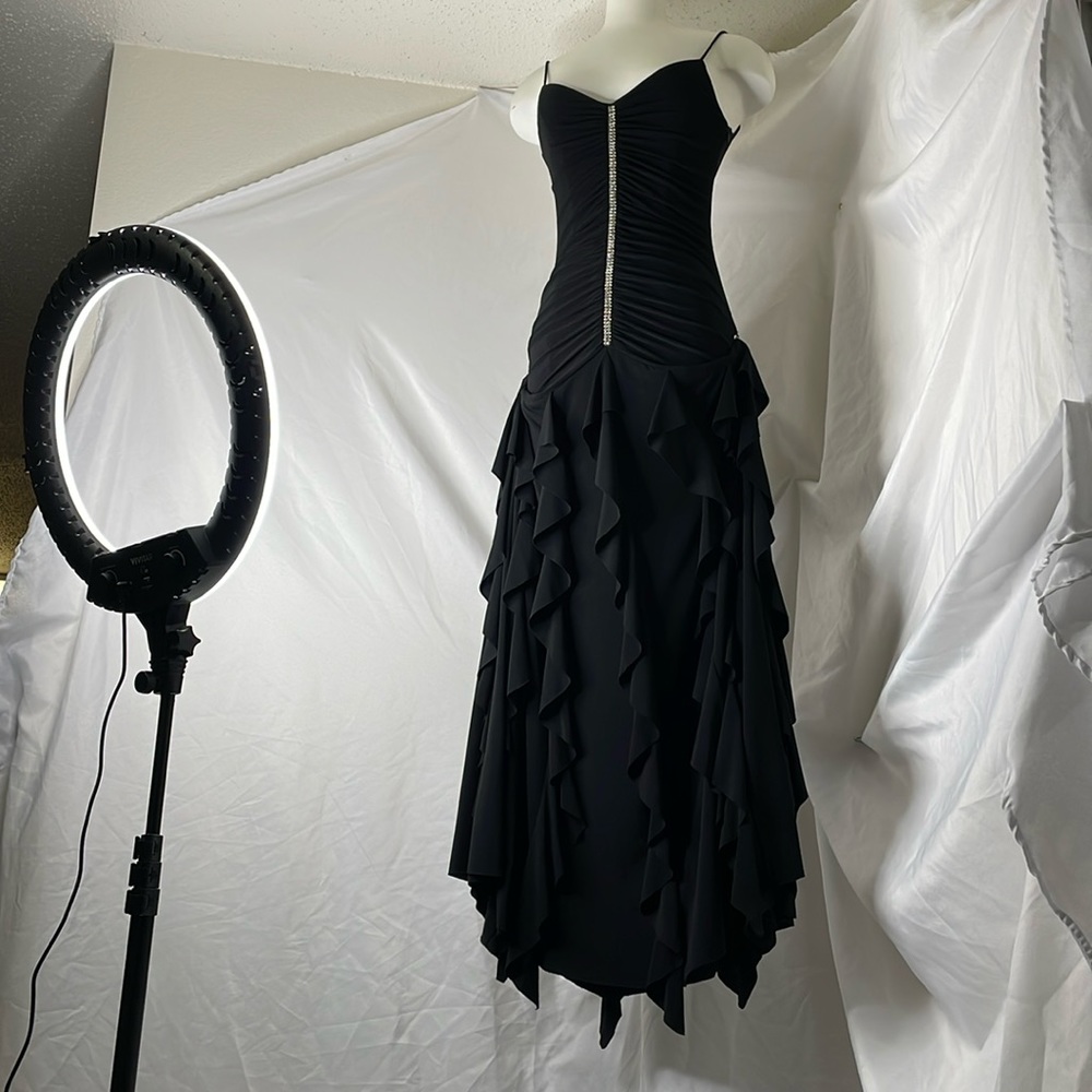 Floor length Slinky black dress with flowy ruffled skirt and rhinestone detail.